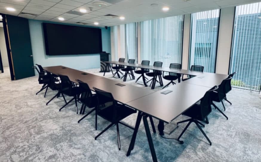 Modern training room with tables, chairs and a large screen