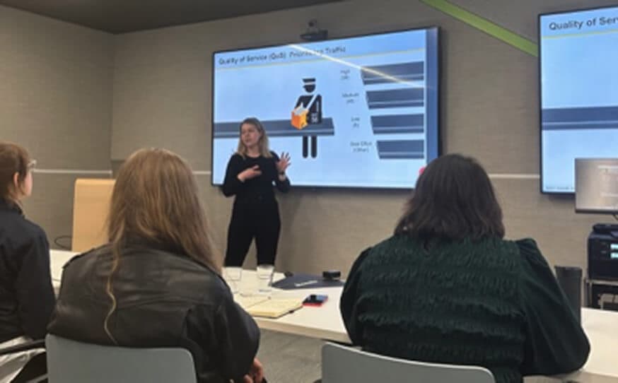 People in a presentation room looking at a large screen